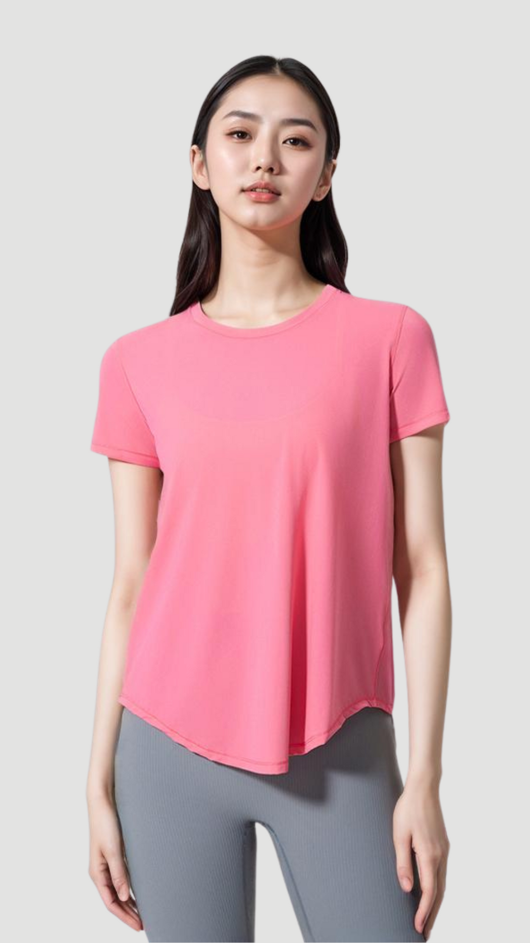 Woman wearing pink Aero Flow Active Tee with round neck, short sleeves, and flowy hem paired with gray leggings