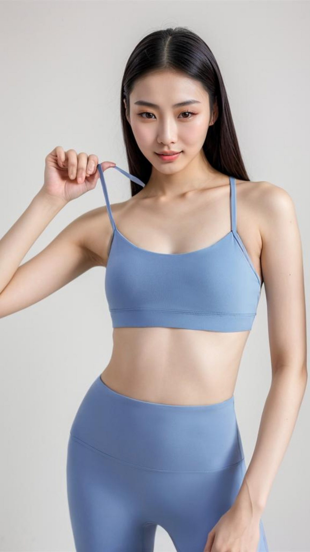 Woman wearing blue AeroFlex Strappy Bra with thin straps and smooth fabric for low-impact workouts.