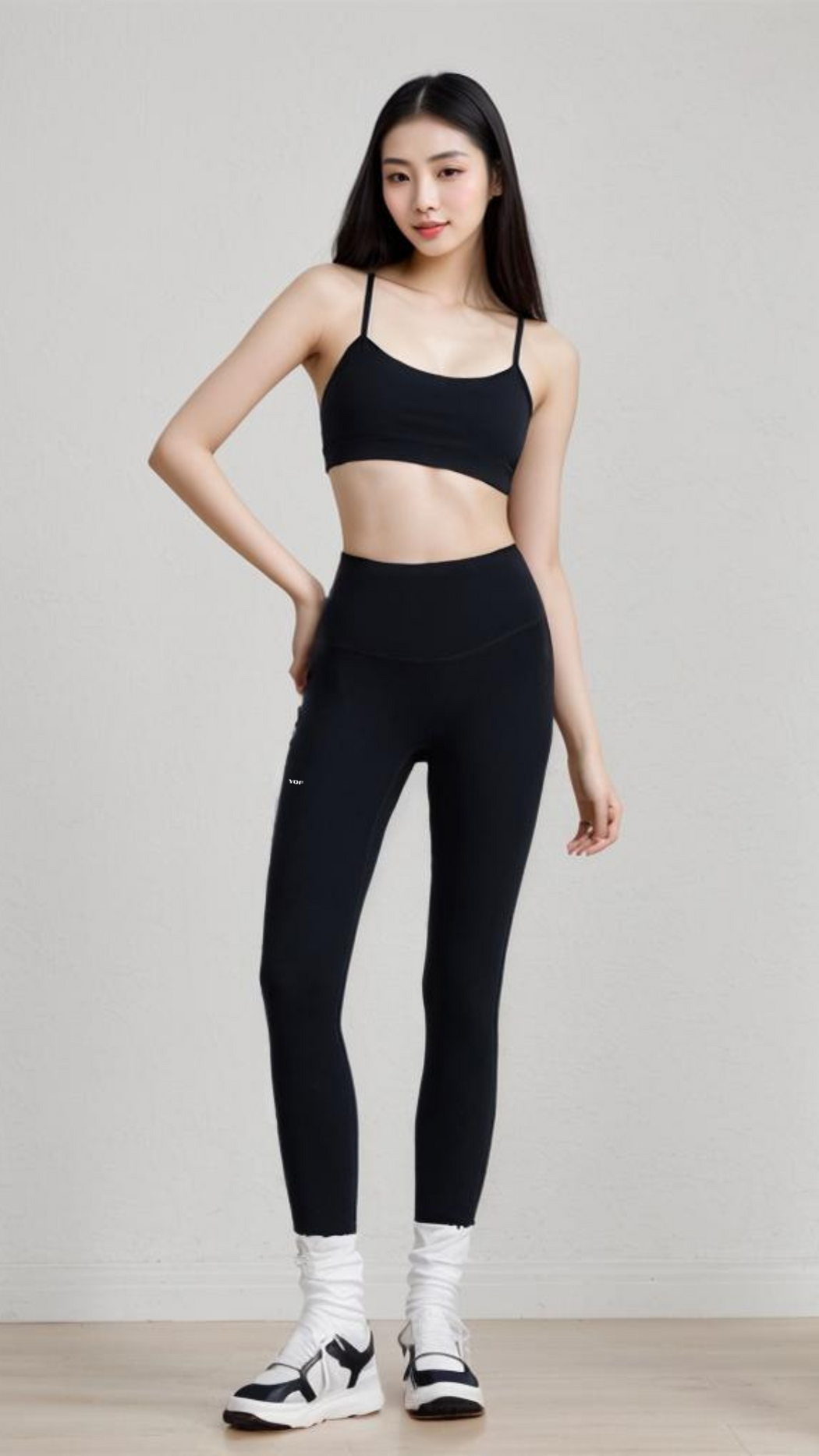 Woman wearing AeroFlex Strappy Bra in black paired with leggings, showcasing a sleek, featherlight workout top.