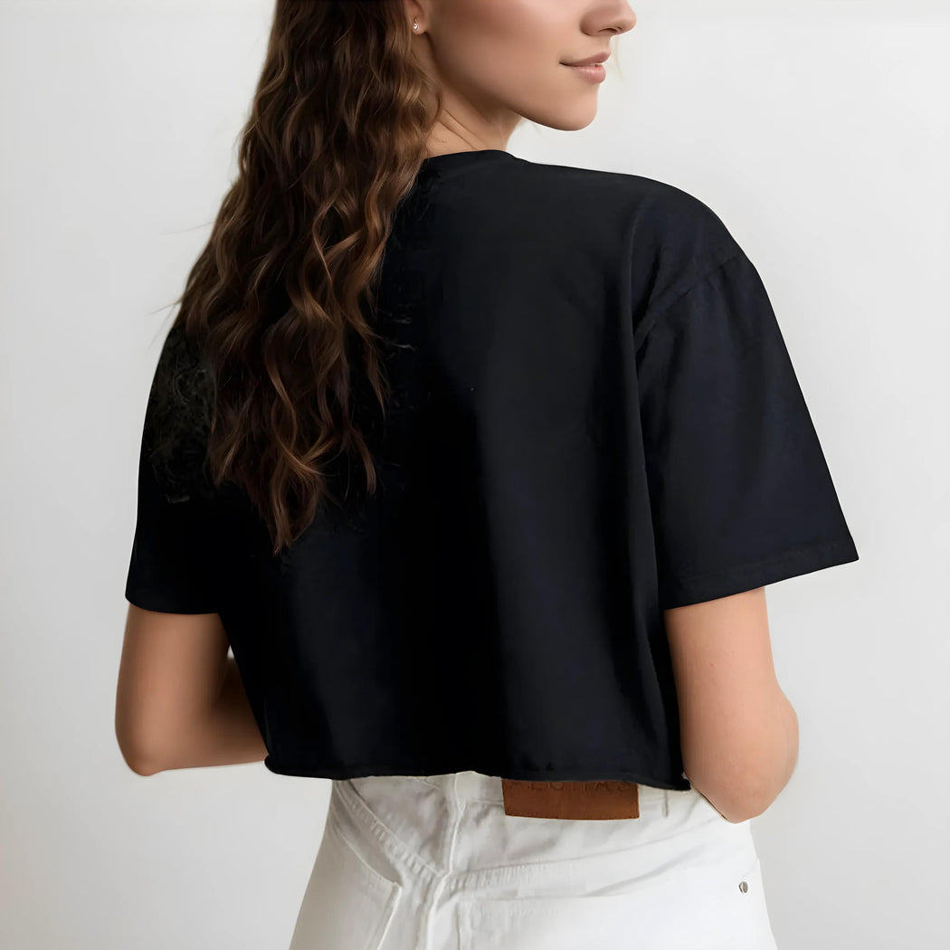 Person wearing a black crop top and white pants against a plain background